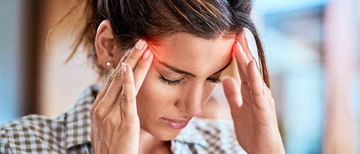 woman with headache holding temples